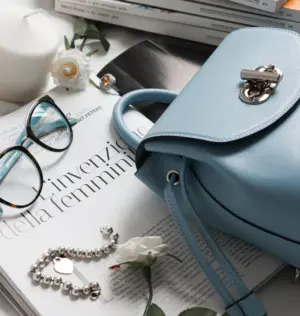 Eyewear, handbag, and books placed neatly on a table